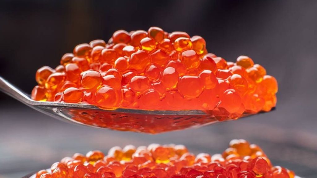 A spoon of orange caviar to be used in frozen desserts